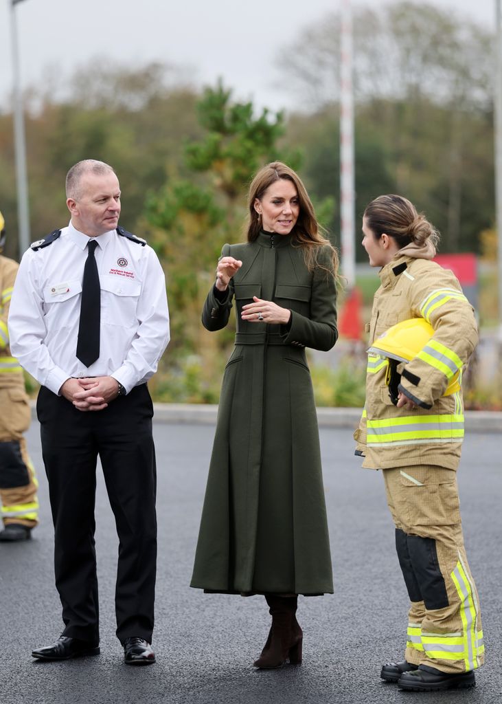 Kate talking to female firefighter and Mark Deeney, Assistant Chief Fire & Rescue Officer in green coat