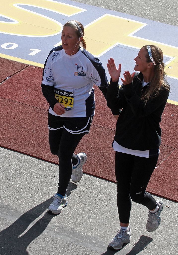 Maureen Brady-Timmons(L), New England Patriots quarterback Tom Brady's sister, gets applause from an unidentified woman after crossing the finish line.