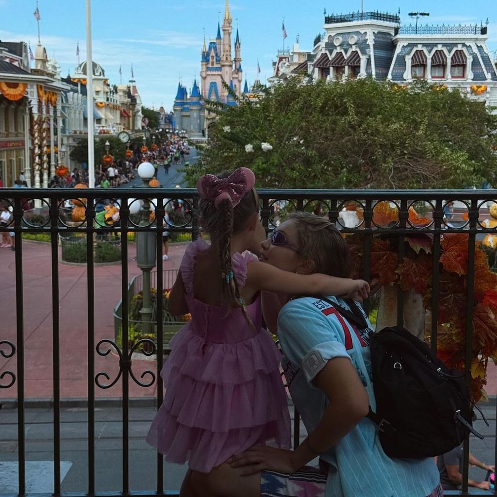 Gigi Hadid crouching next to her daughter at Disneyland