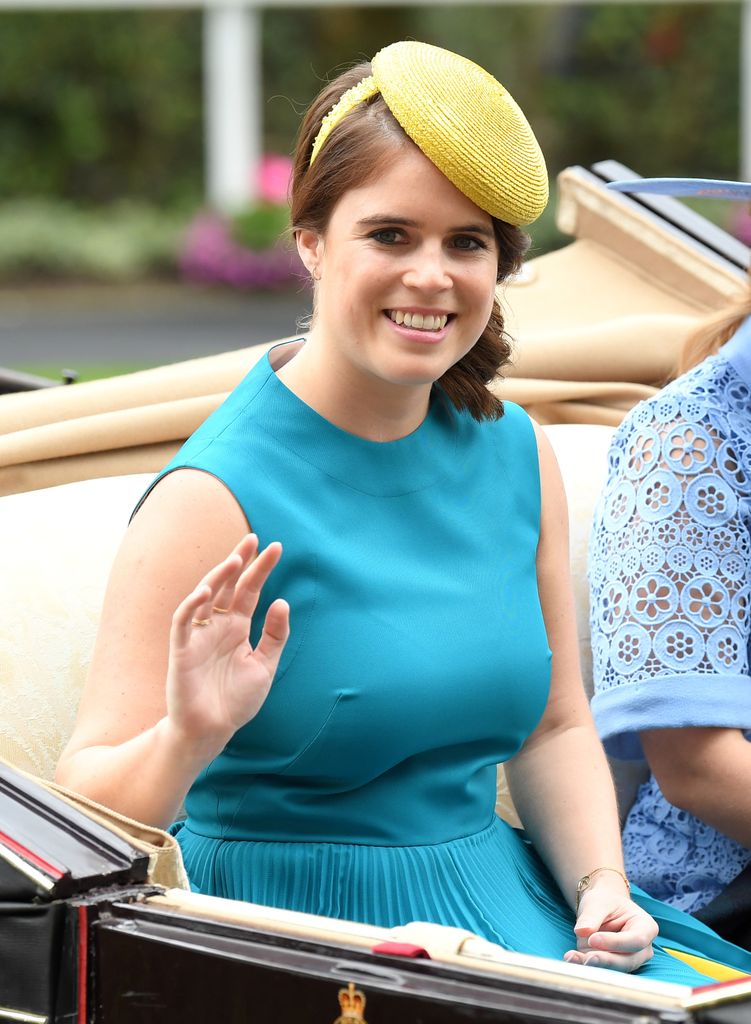 Princess Eugenie smiling and waving in a yellow hat