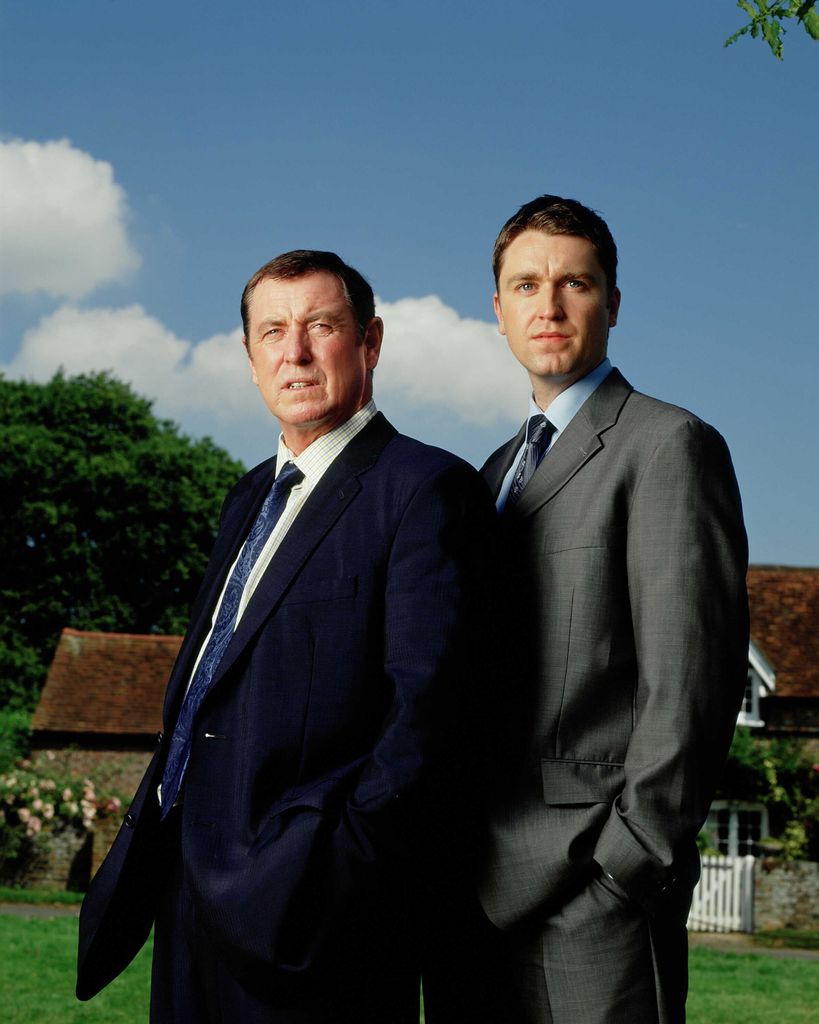 two detectives standing on grass on sunny day