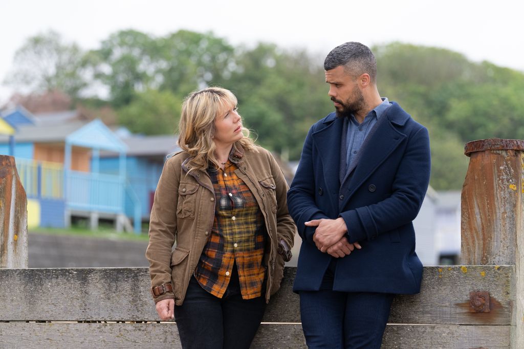 woman and man leaning against fence