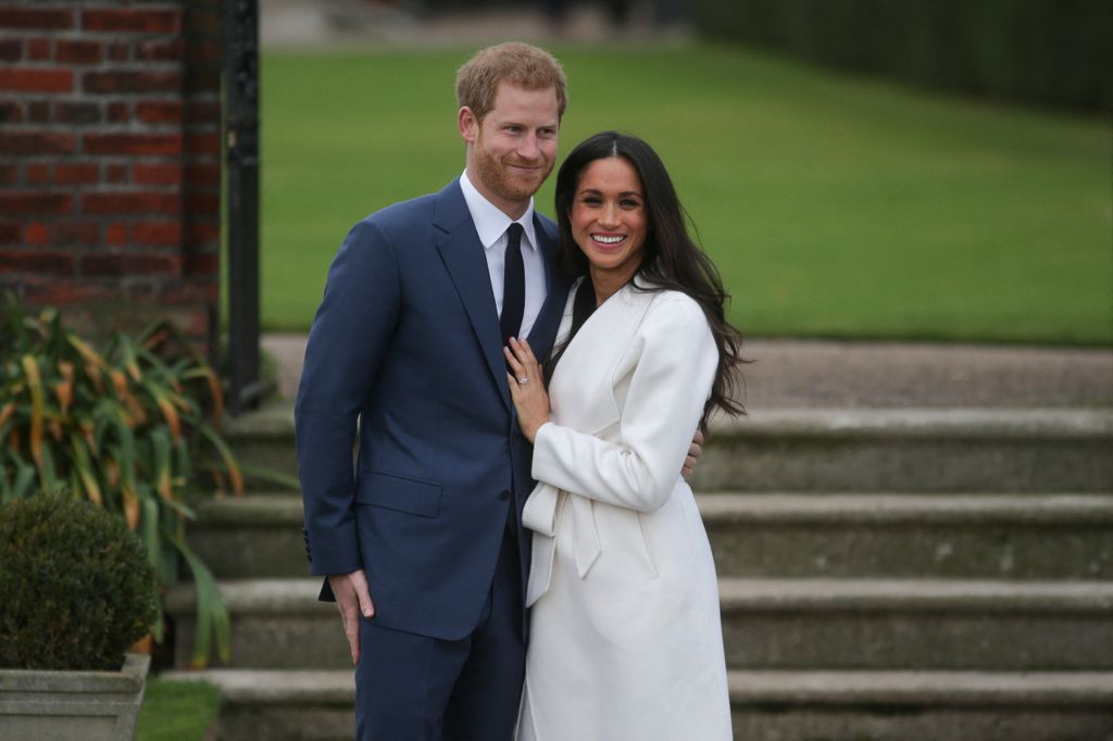 Britain's Prince Harry stands with his fiancÃ©e US actress Meghan Markle as she shows off her engagement ring whilst they pose for a photograph in the Sunken Garden at Kensington Palace in west London on November 27, 2017, following the announcement of their engagement. Britain's Prince Harry will marry his US actress girlfriend Meghan Markle early next year after the couple became engaged earlier this month, Clarence House announced on Monday. (Photo by Daniel LEAL / AFP) (Photo by DANIEL LEAL/AFP via Getty Images)