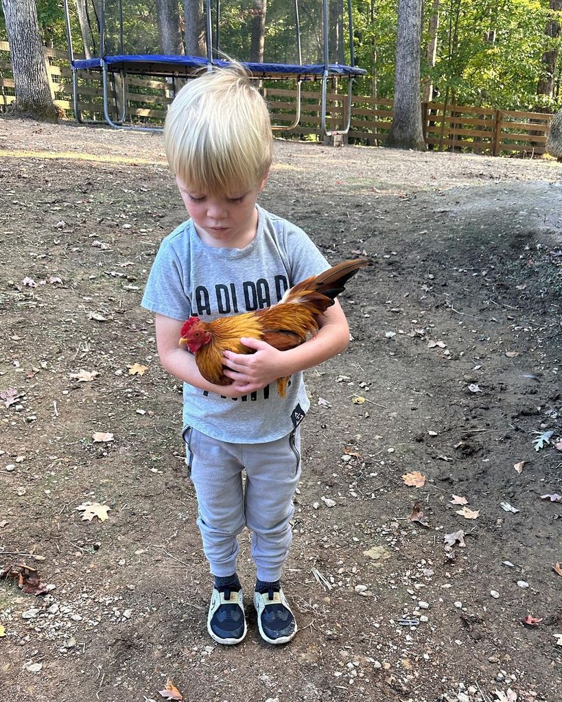 Christina Hall's son Hudson plays with the family rooster