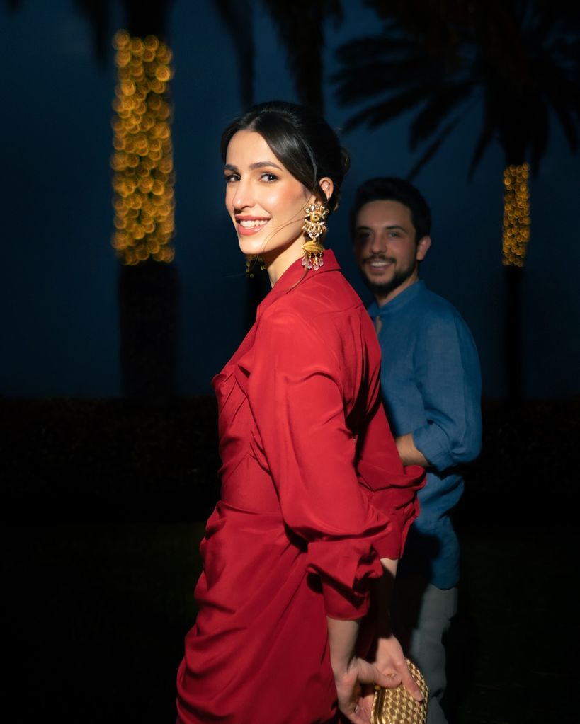 Princess Rajwa wearing red dress and gold earrings