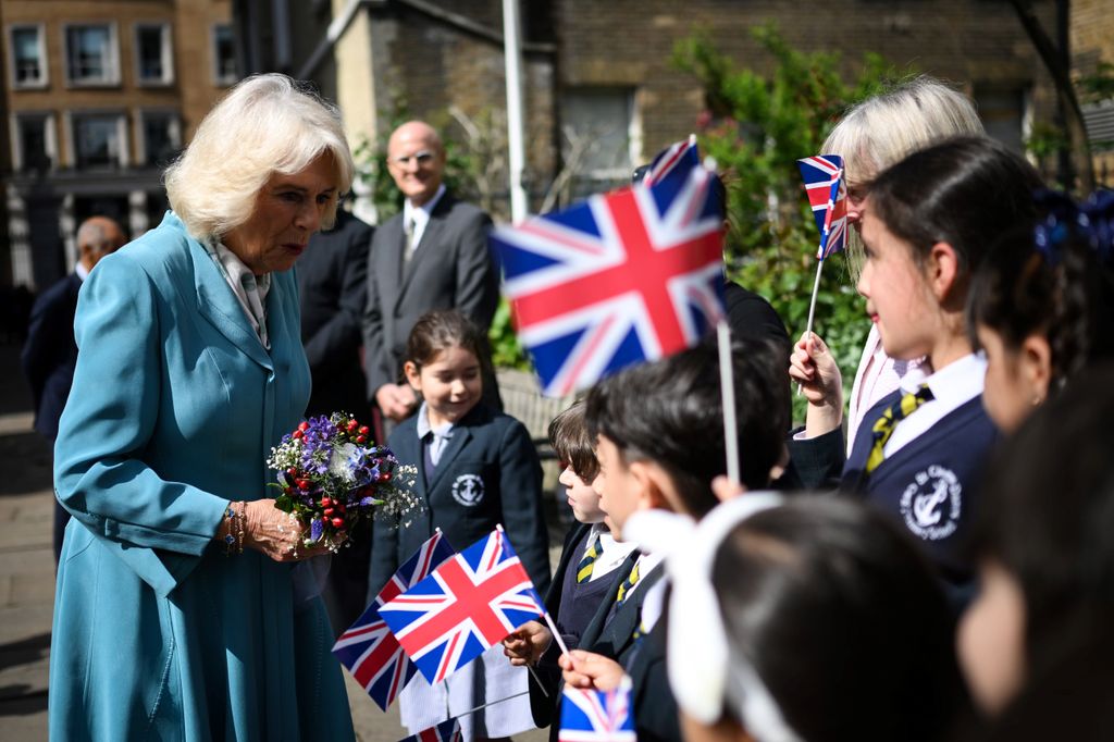 Queen Camilla greets school children outside the church