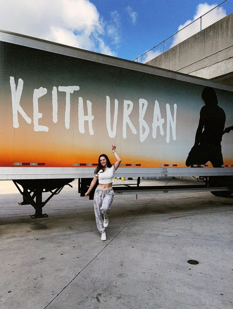 maggie baugh pointing to keith urban emblazoned plane