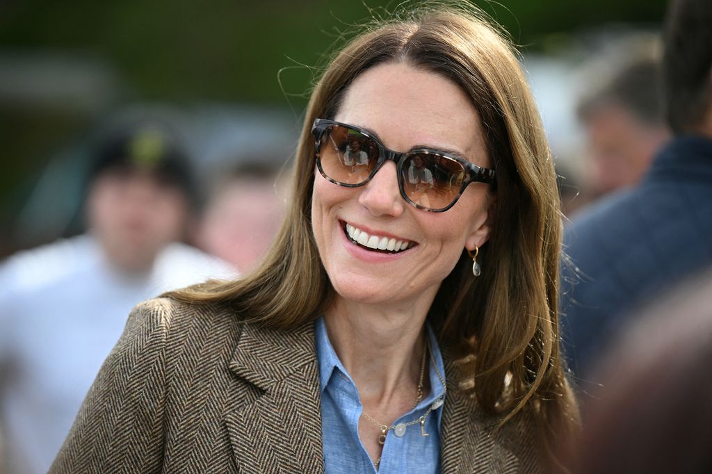 Kate Middleton wearing sunglasses, checked blazer and blue shirt