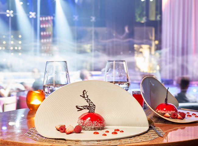 Two desserts on a dining table with Chic Restaurant stage lights behind