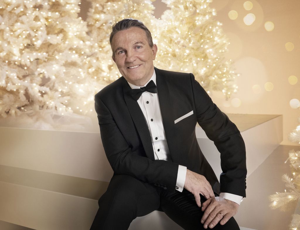 Man in tuxedo smiling while sitting down