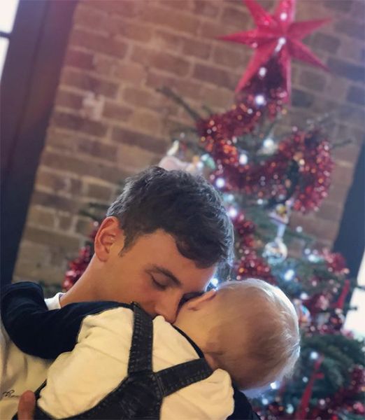 Tom Daley and son in front of Christmas tree