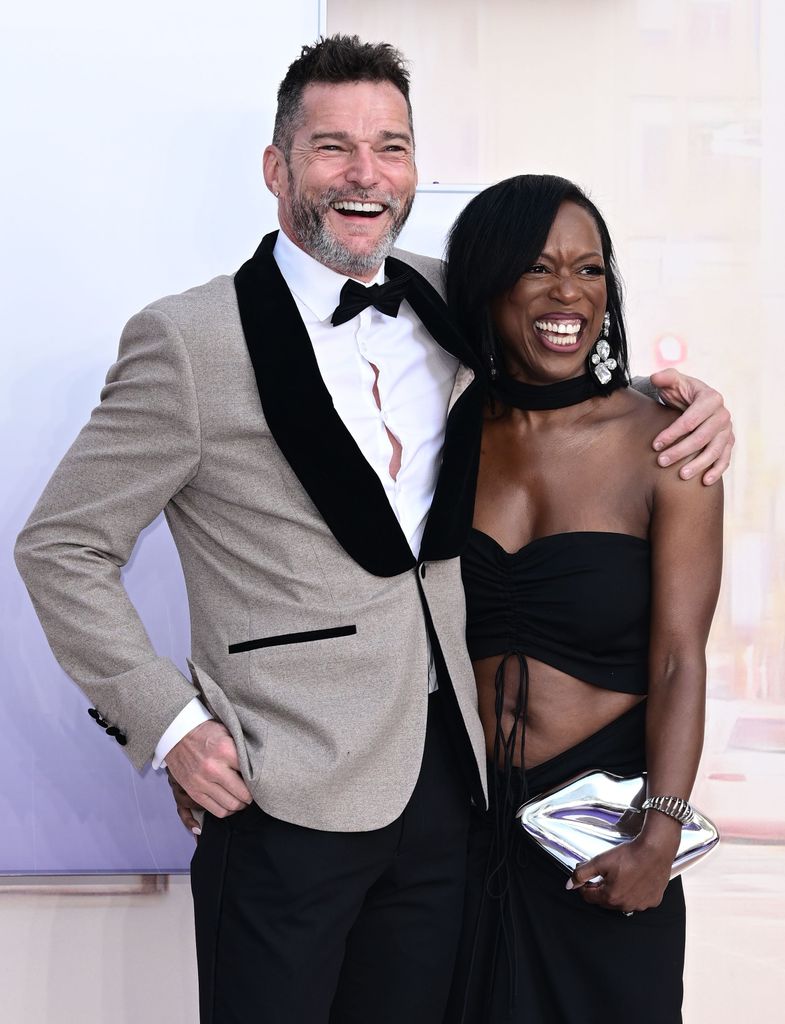 Man and woman with arms around each other smiling for photos