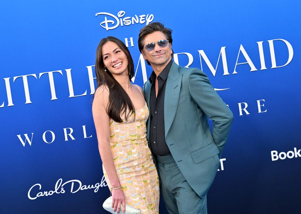 Caitlin McHugh and John Stamos attend the World Premiere of Disney's "The Little Mermaid" on May 08, 2023 in Hollywood, California