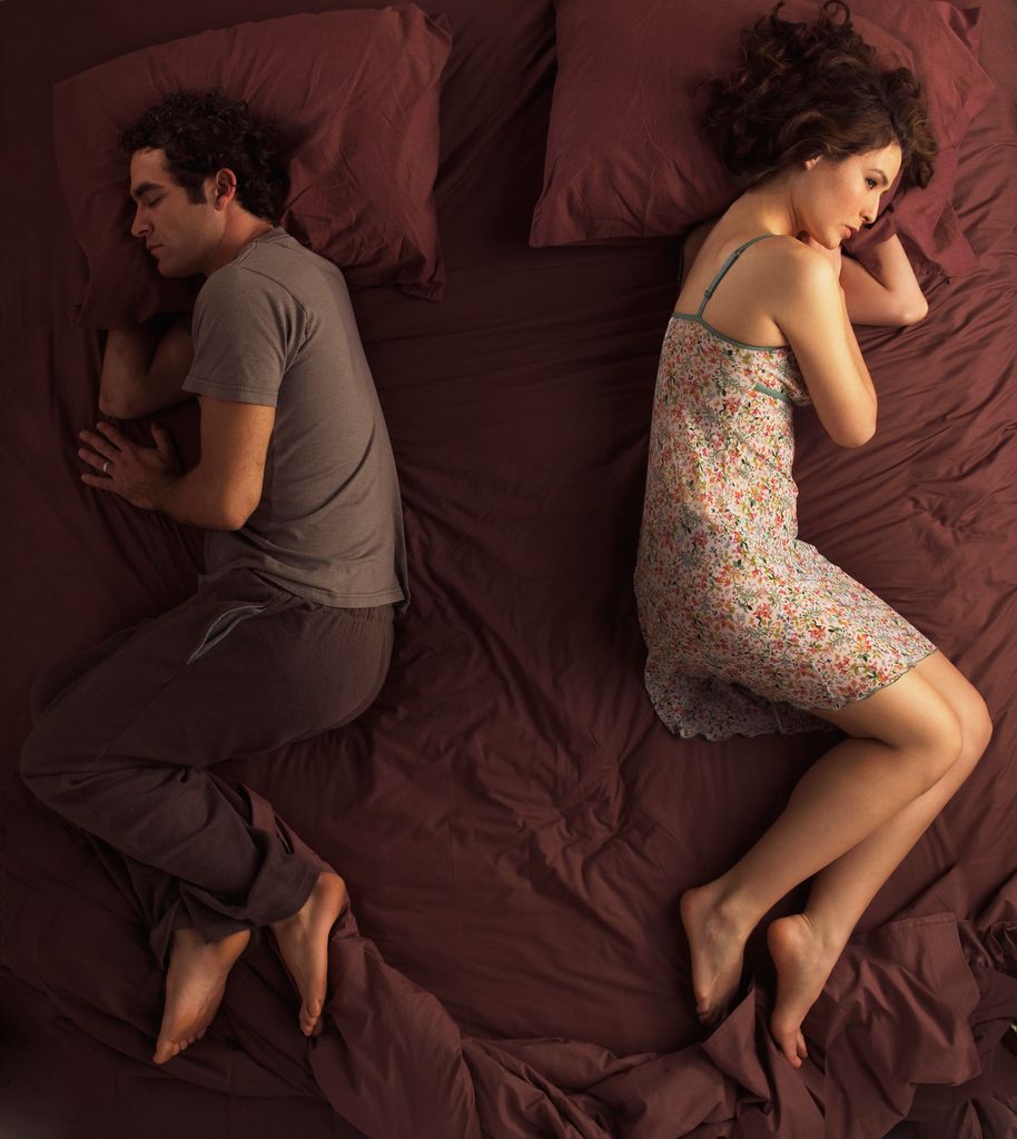 Unhappy couple sleeping in bed