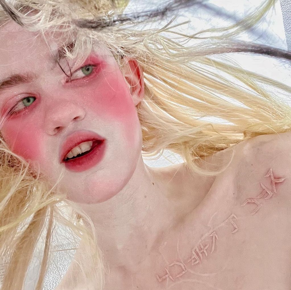 Grimes showed off her white chest tattoo with blonde hair and pink blusher