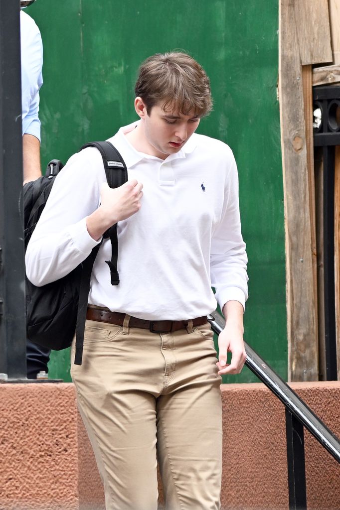 Barron Trump in white polo shirt and beige trousers