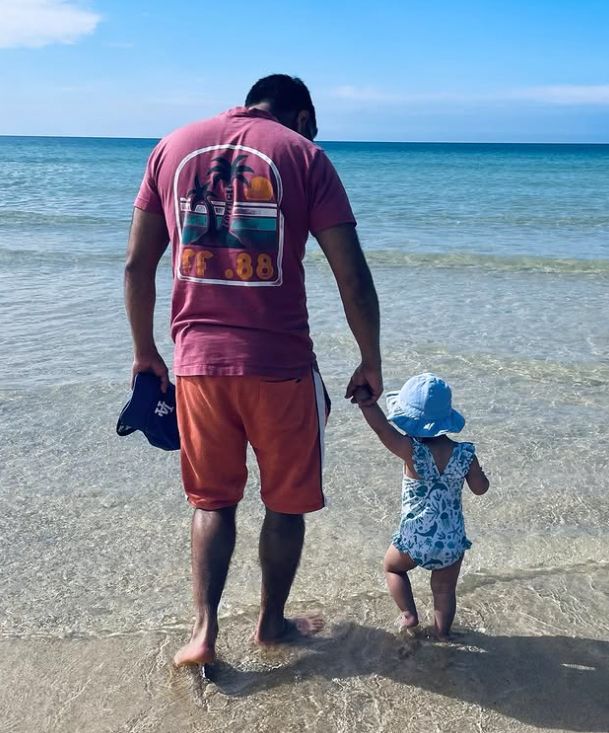 Nick Mohammed walking into the sea with his daughter