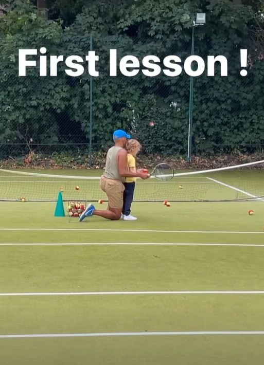 A tennis coach helping a child play tennis