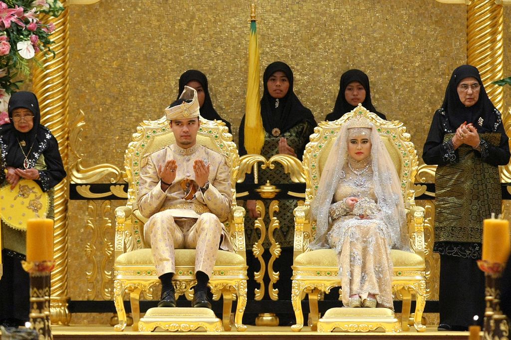 Princess Hajah Hafizah Sururul Bolkiah sitting in a throne next to her groom Pengiran Haji Muhammad Ruzaini