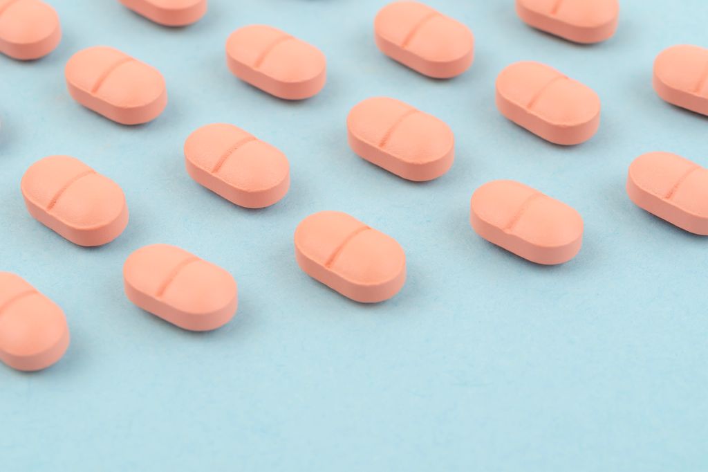 Pink tablets on a blue background, Healthcare and medicine concept