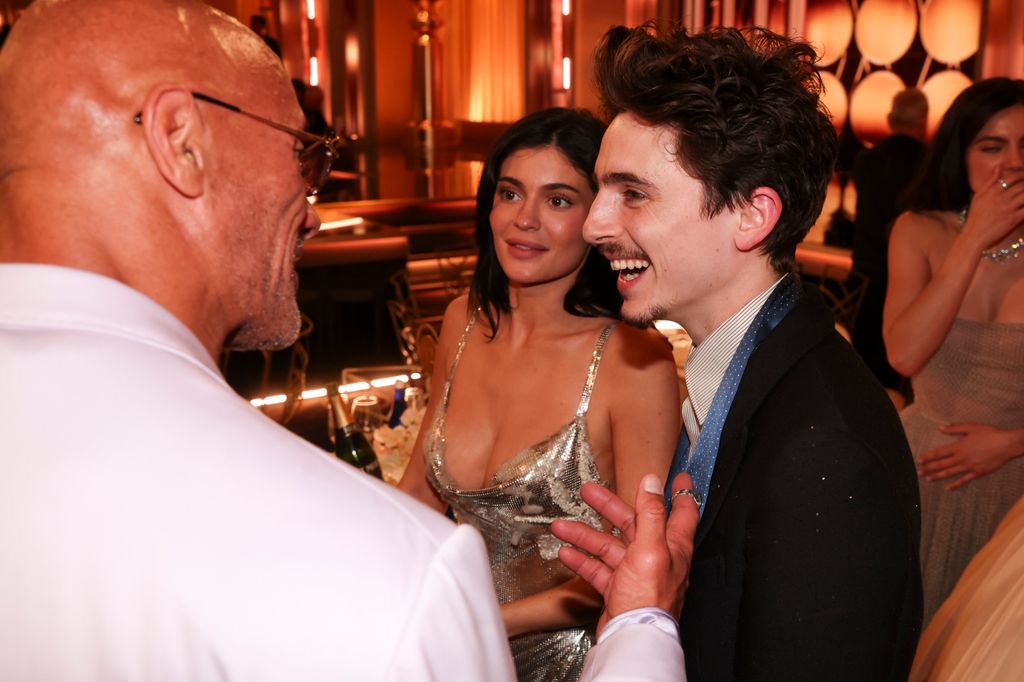 Kylie Jenner and Timothée Chalamet talking to The Rock during the 82nd Annual Golden Globes