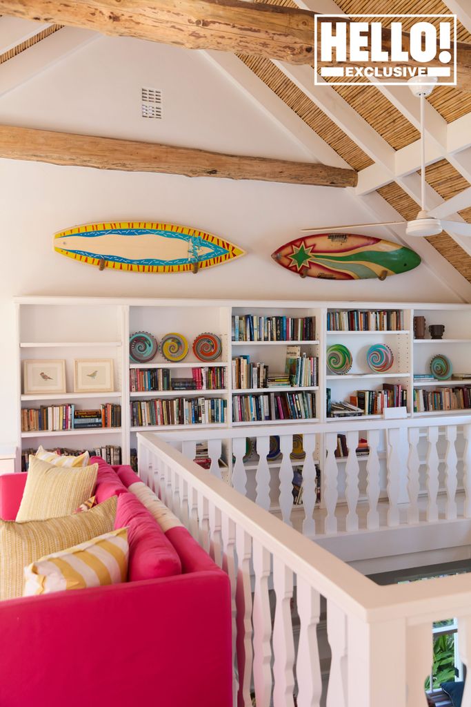 Tabitha Webb amazing hallway at South Africa home with bookshelves and decorative surfboards