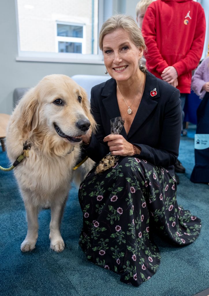 Sophie crouching down with golden retriever