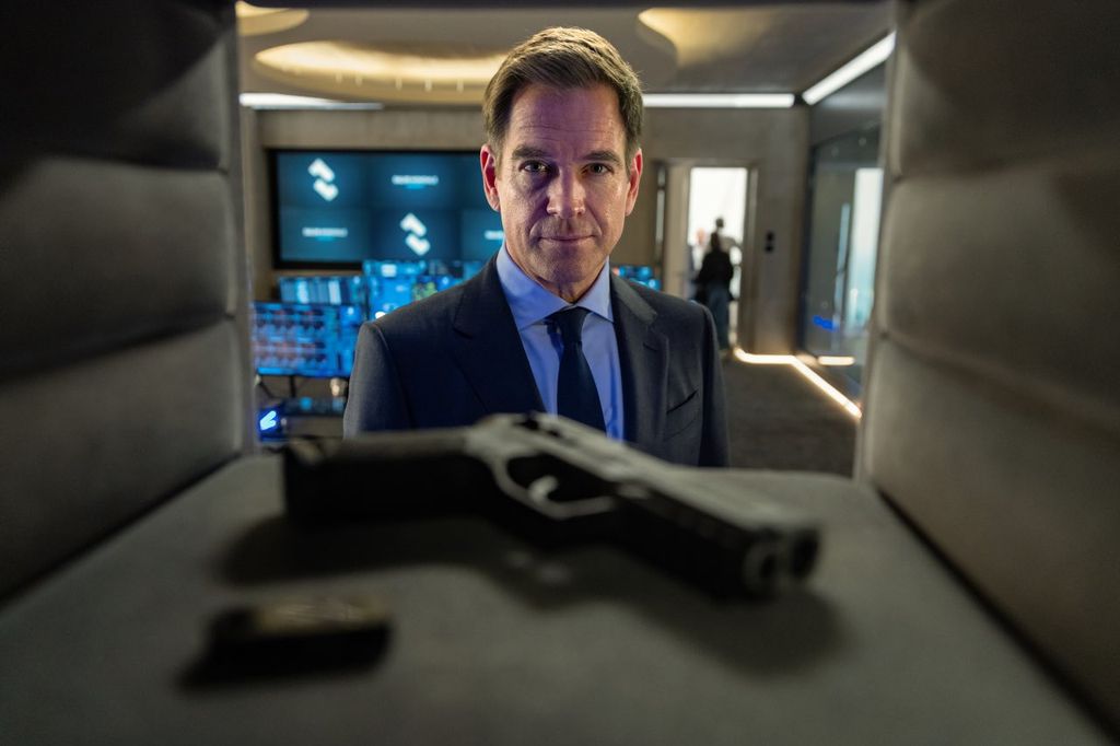 close-up of man looking at gun in safe