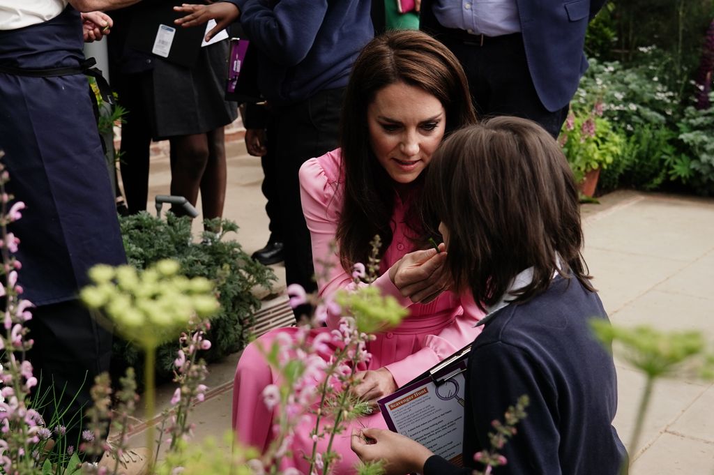Kate Middleton shows a child a flower in the Chelsea Flower Show