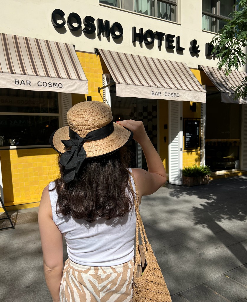 woman in hat outside of cosmo hotel