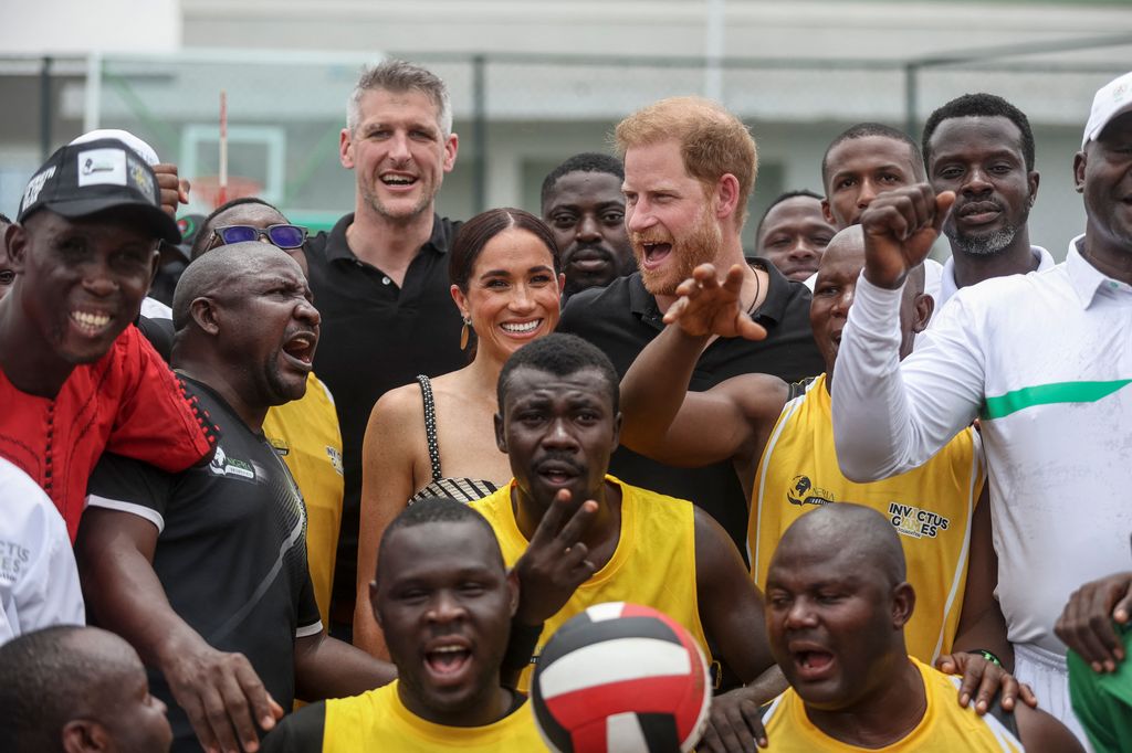 Prince Harry and Meghan Markle pose for photographs with players ahead of an exhibition sitting volleyball match at Nigeria Unconquered, a local charity organisation that supports wounded, injured, or sick servicemembers, in Abuja