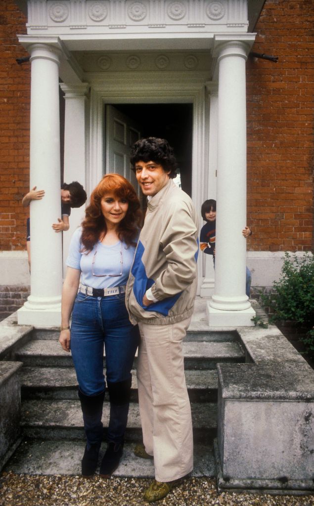 Tom Stoppard and Miriam Stern standing in front of their house with two children in the background