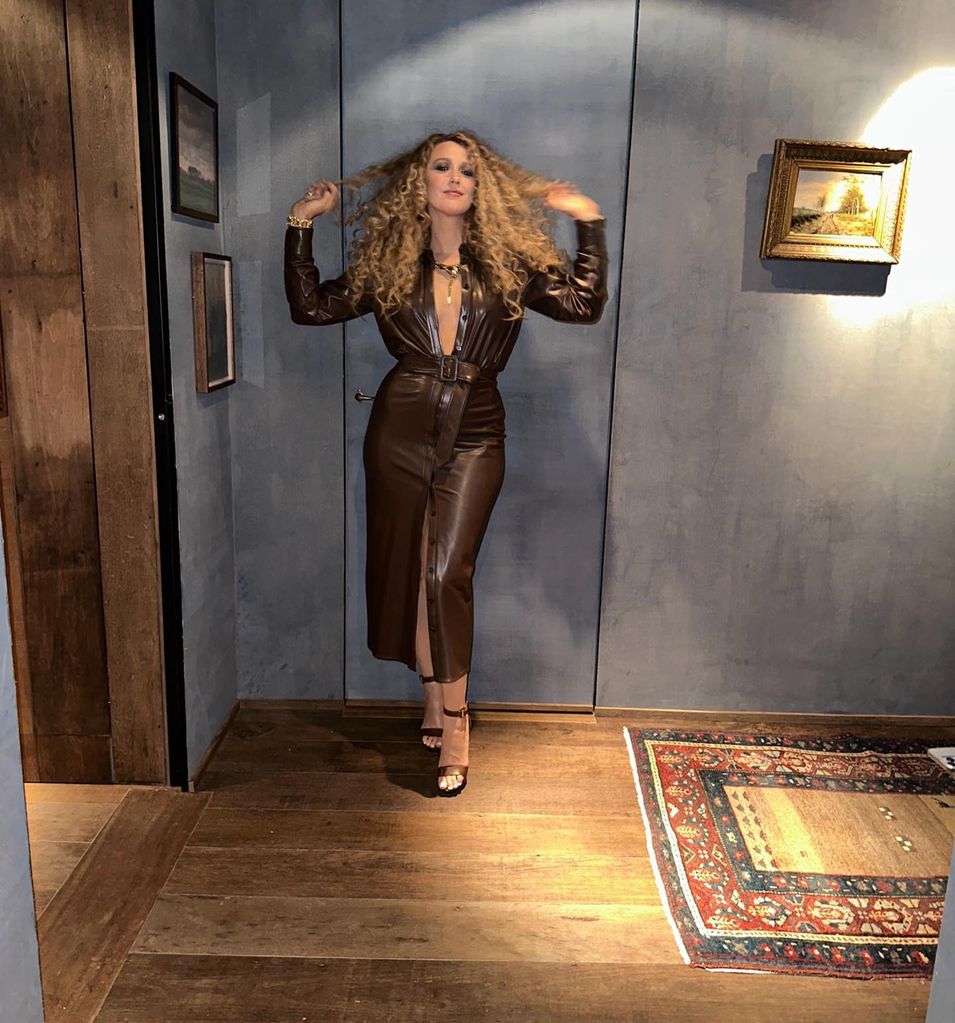 Blake in leather dress in her apartment foyer