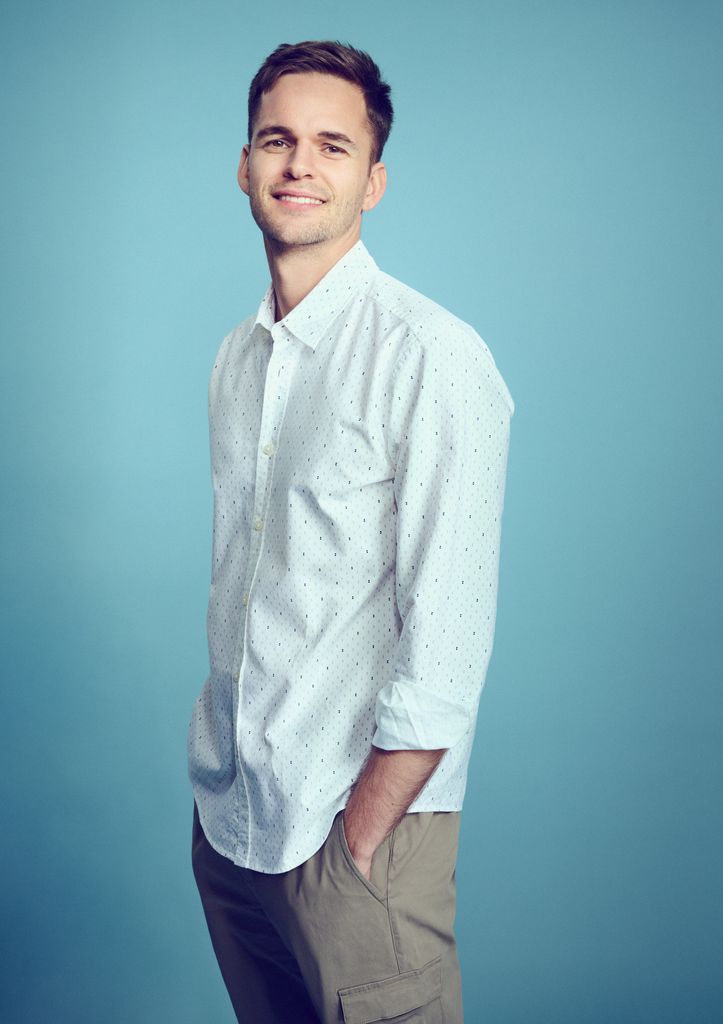 Smart man smiling in front of a blue background