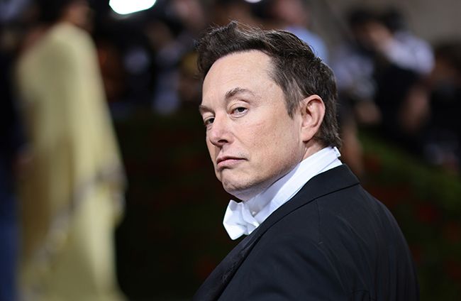 Elon Musk looks over his should while on red carpet at Met Gala