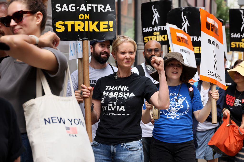 Cynthia Nixon (C) joins SAG-AFTRA members on the picket line outside of Netflix and Warner Bros on July 21, 2023 in New York City. Members of SAG-AFTRA, Hollywood's largest union which represents actors and other media professionals, have joined striking 