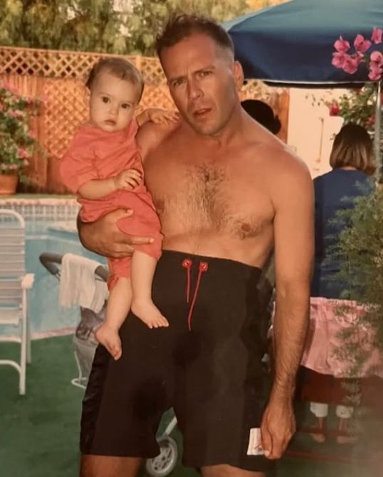 Photo of Bruce Willis holding a young girl