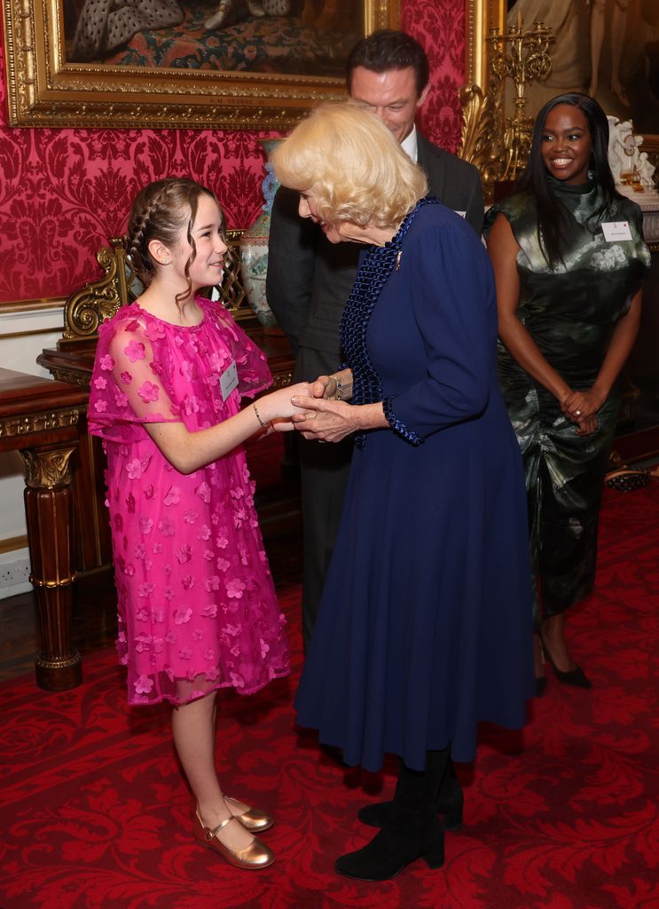 Queen Camilla shaking Alisha Weir's hand