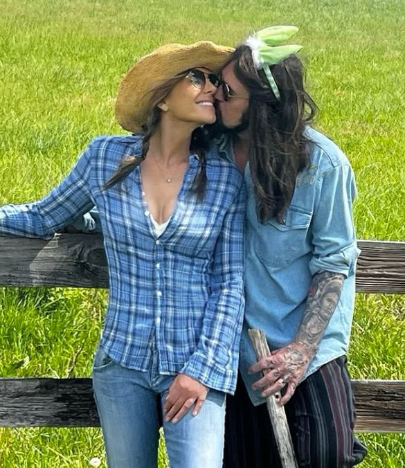 Billy Ray Cyrus in a denim shirt kissing Elizabeth Hurley in a plaid outfit