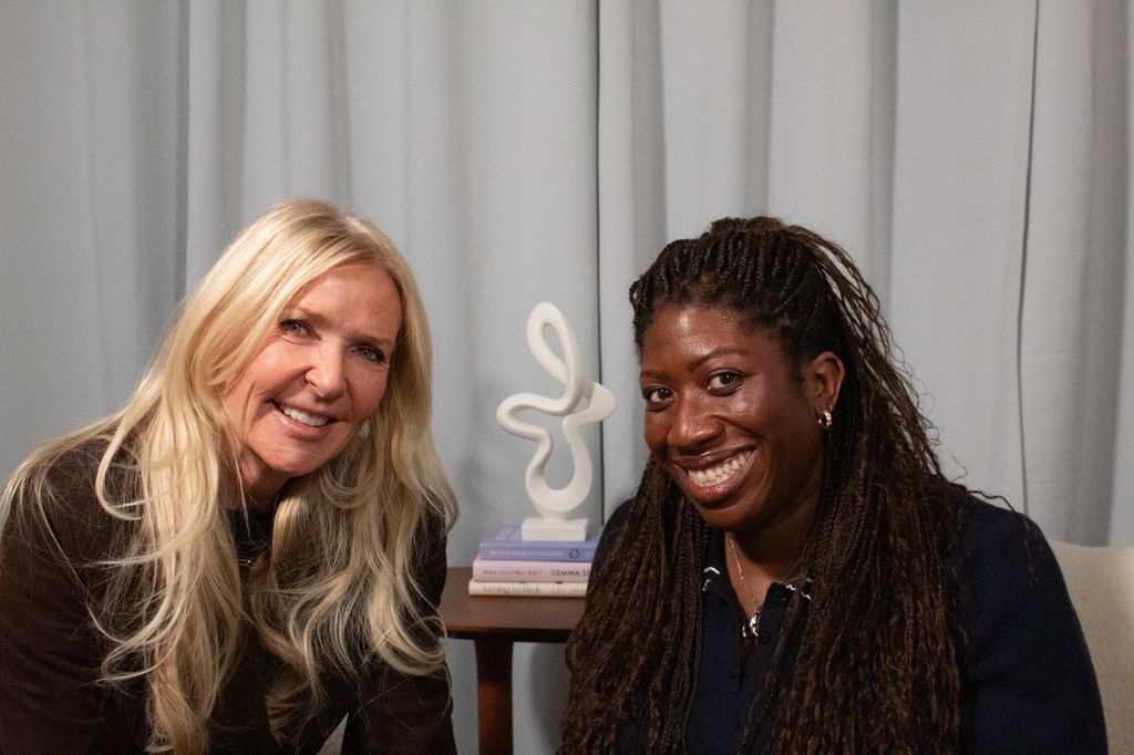 two women smiling in a podcast studio