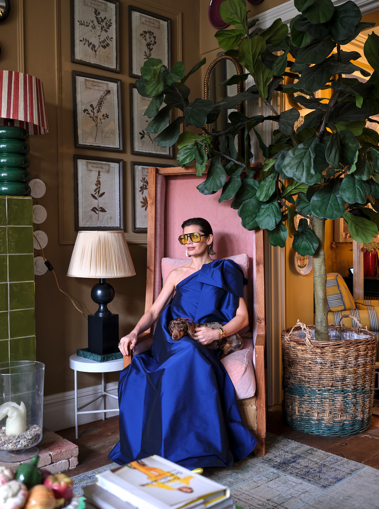 Sarah sits in a cherised pink chair that her husband designed