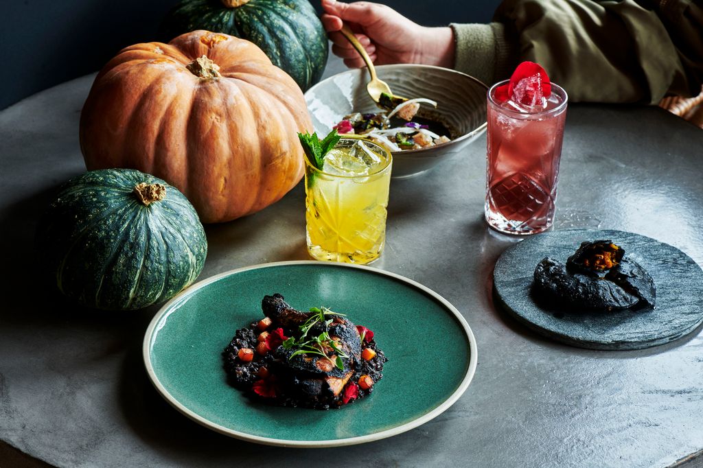 treehouse halloween dishes with pumpkins and two cocktails on a table
