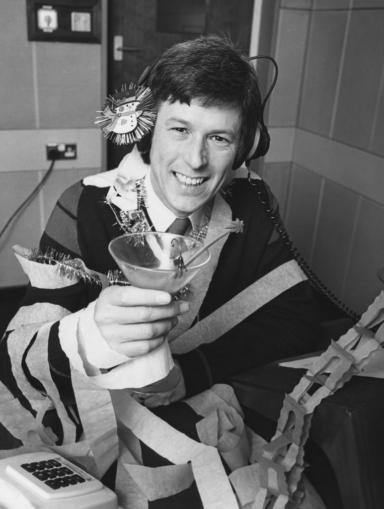 Black-and-white photo of John Craven holding a martini glass