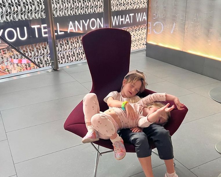 Two children sleeping on a chair