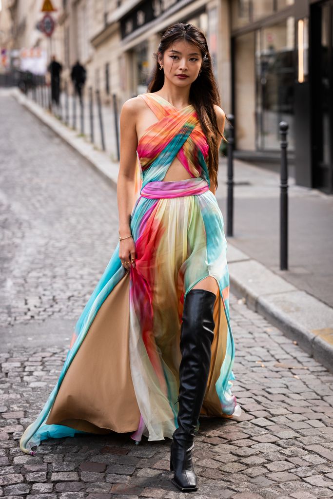 A guest wears a colorful maxi dress and black over the knees boots, outside Zuhair Murad, during the Haute Couture Fall/Winter 2023/2024 as part of  Paris Fashion Week on July 05, 2023 in Paris, France. (Photo by Claudio Lavenia/G