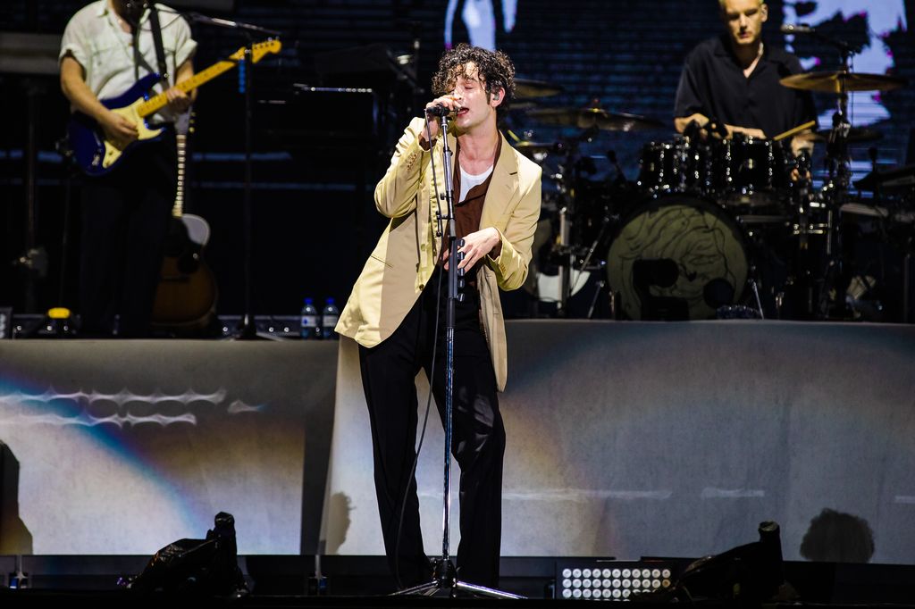 Matty Healy performs in a suit