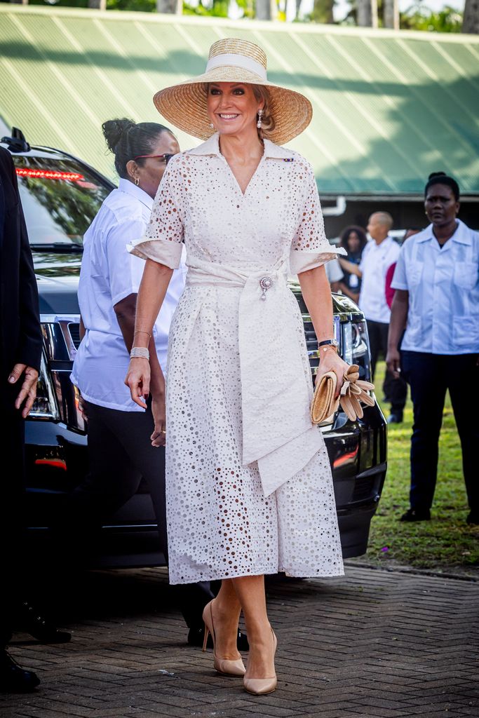 Queen Maxima in white sundress and wide straw hat smiling