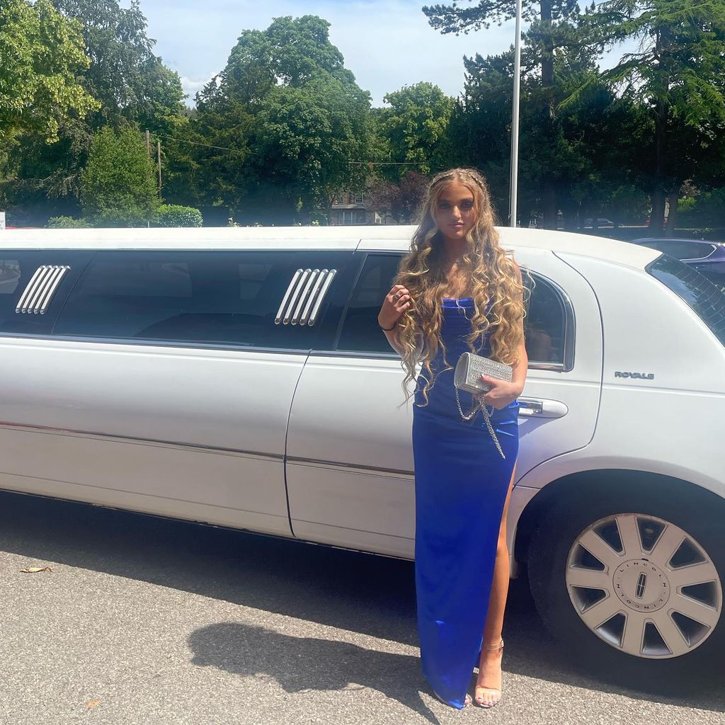 princess andre wearing blue dress standing in front of limo