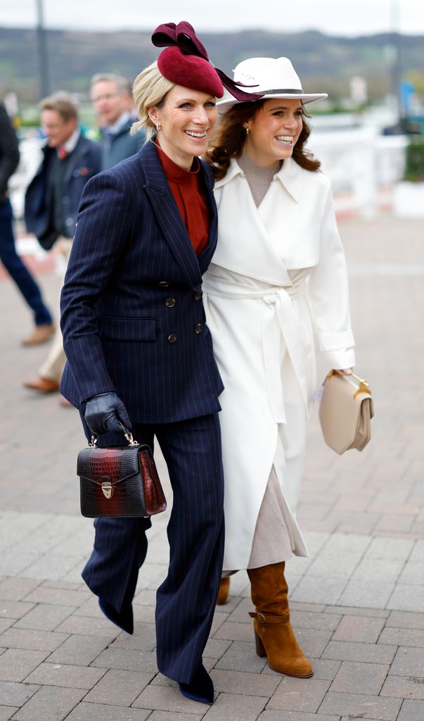 zara tindall and princess eugenie smiling at cheltenham festival