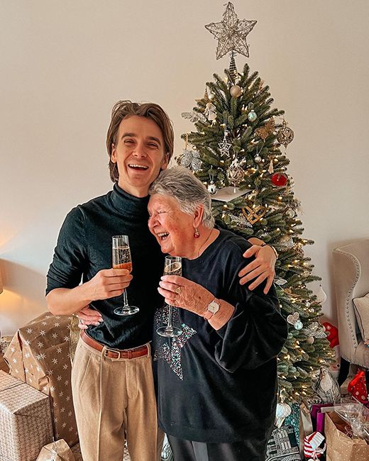 youtuber joe sugg hugging his grandmother in front of christmas tree